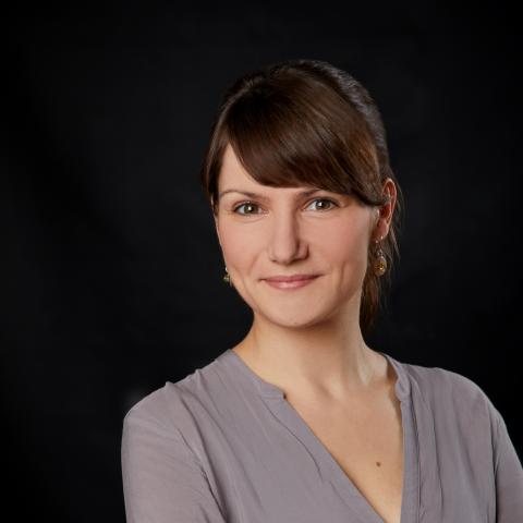 portrait picture of a brown-haired woman with a gray shirt
