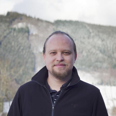 Andreas Hauptmann in front of mountain and forest