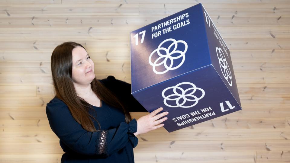 Tanja Kähkönen pitelee laatikkoa, jossa on teksti partnerships for the goals