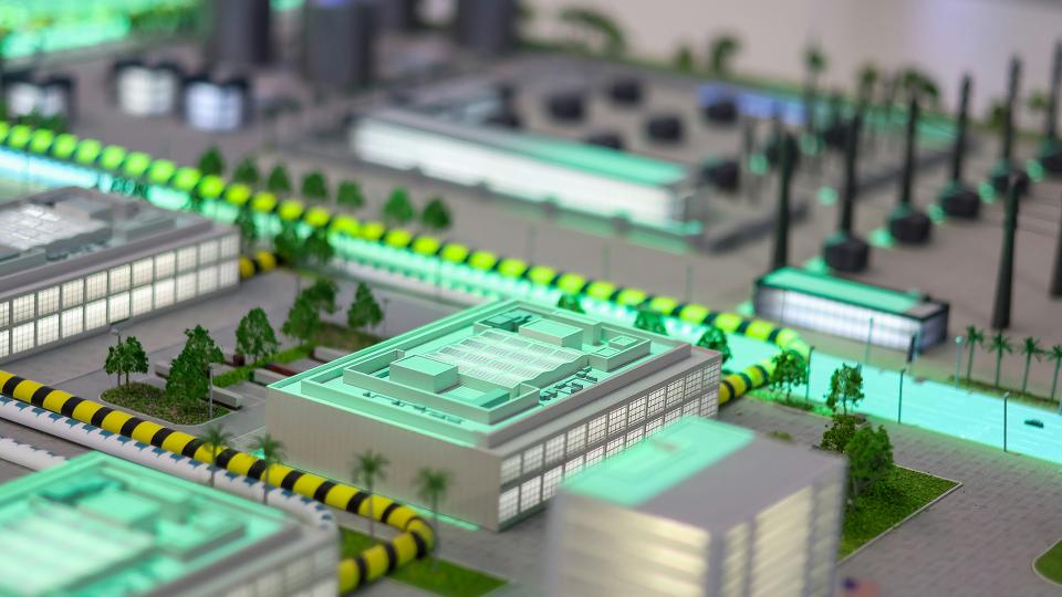 Detailed miniature model of a modern city with illuminated buildings, roads, and advanced infrastructure.