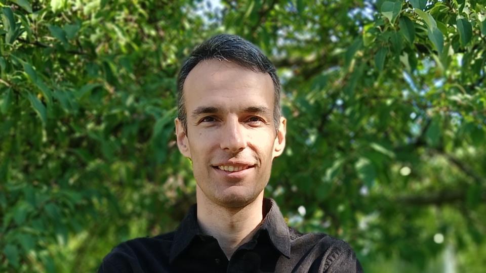 hassan yazdanian smiling in front of trees