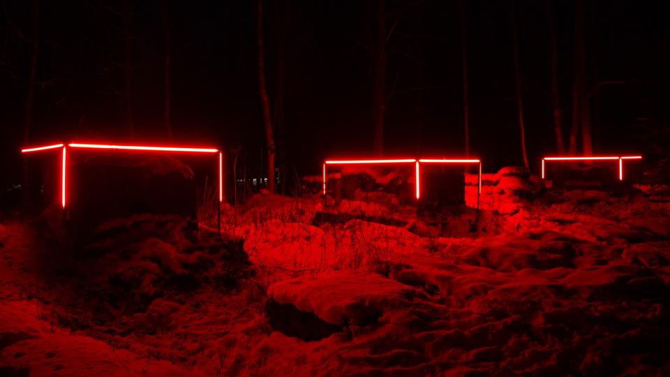 Punaisia valoja lumisessa metsässä