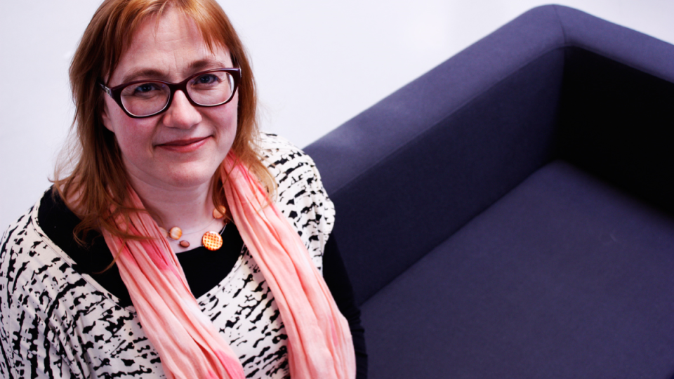 Picture of researcher Eeva-Liisa Oikarinen sitting in sofa, picture credit Hanna Talikka