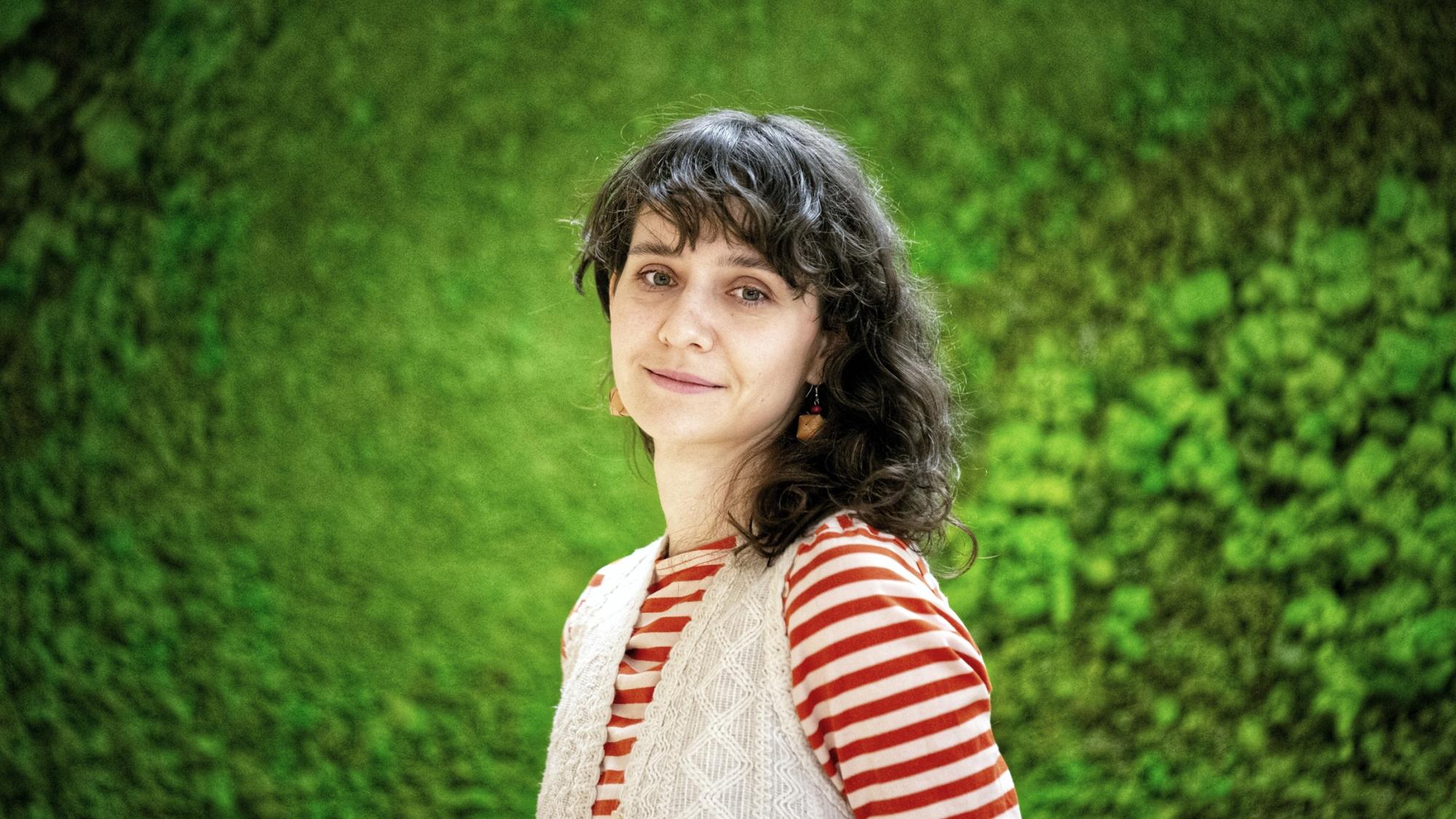 A picture of a dark-haired woman looking into the camera, smiling.