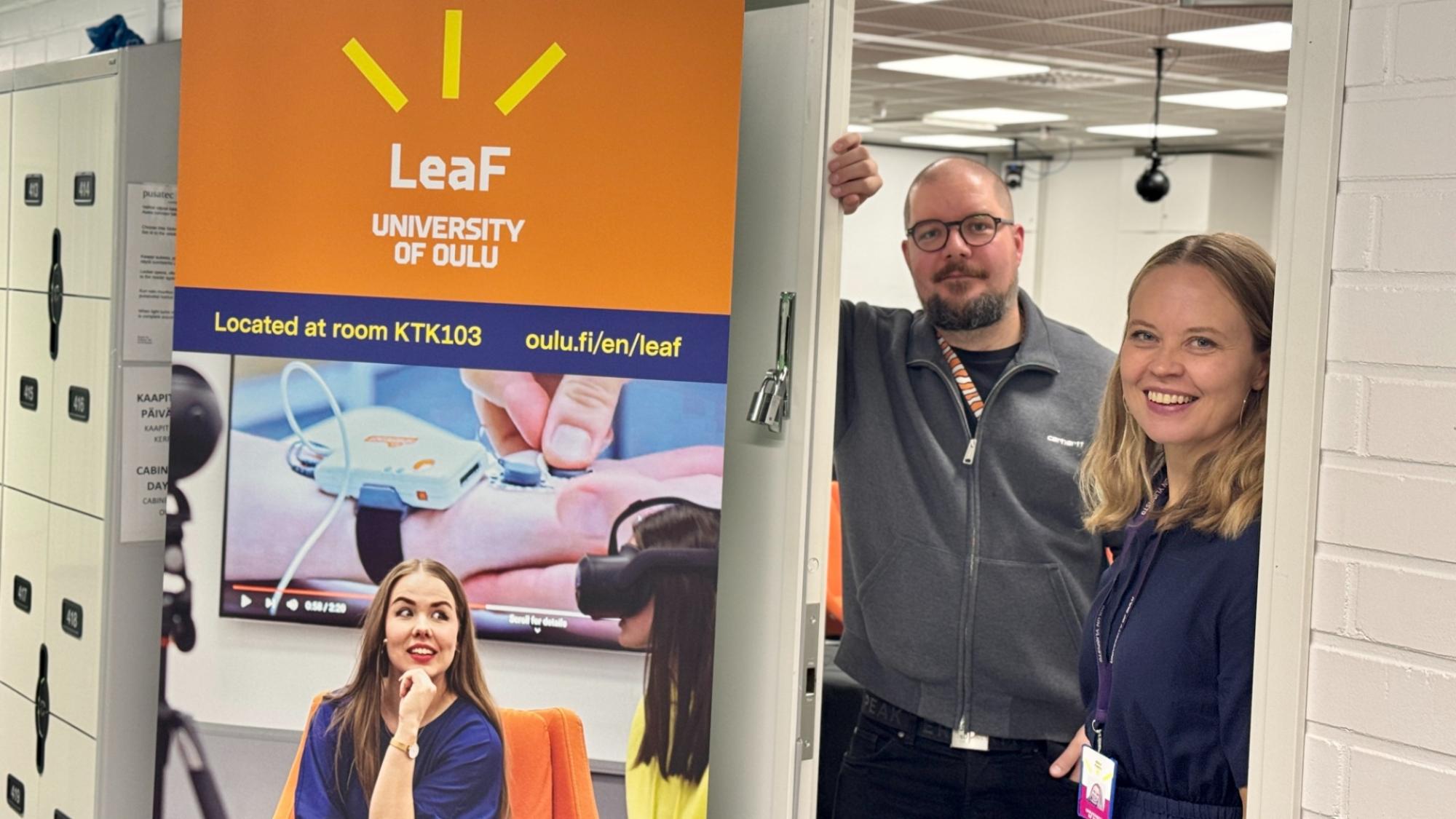 A man and a woman smiling at the door of LeaF space at the University of Oulu