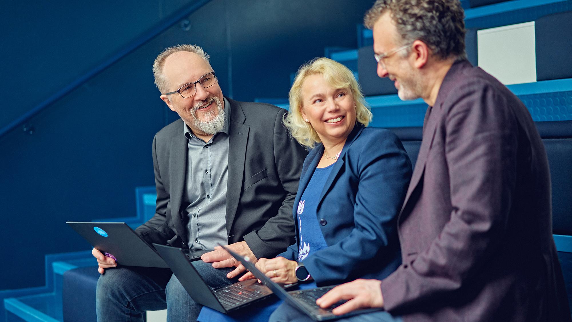 kaksi miestä ja yksi nainen keskustelemassa