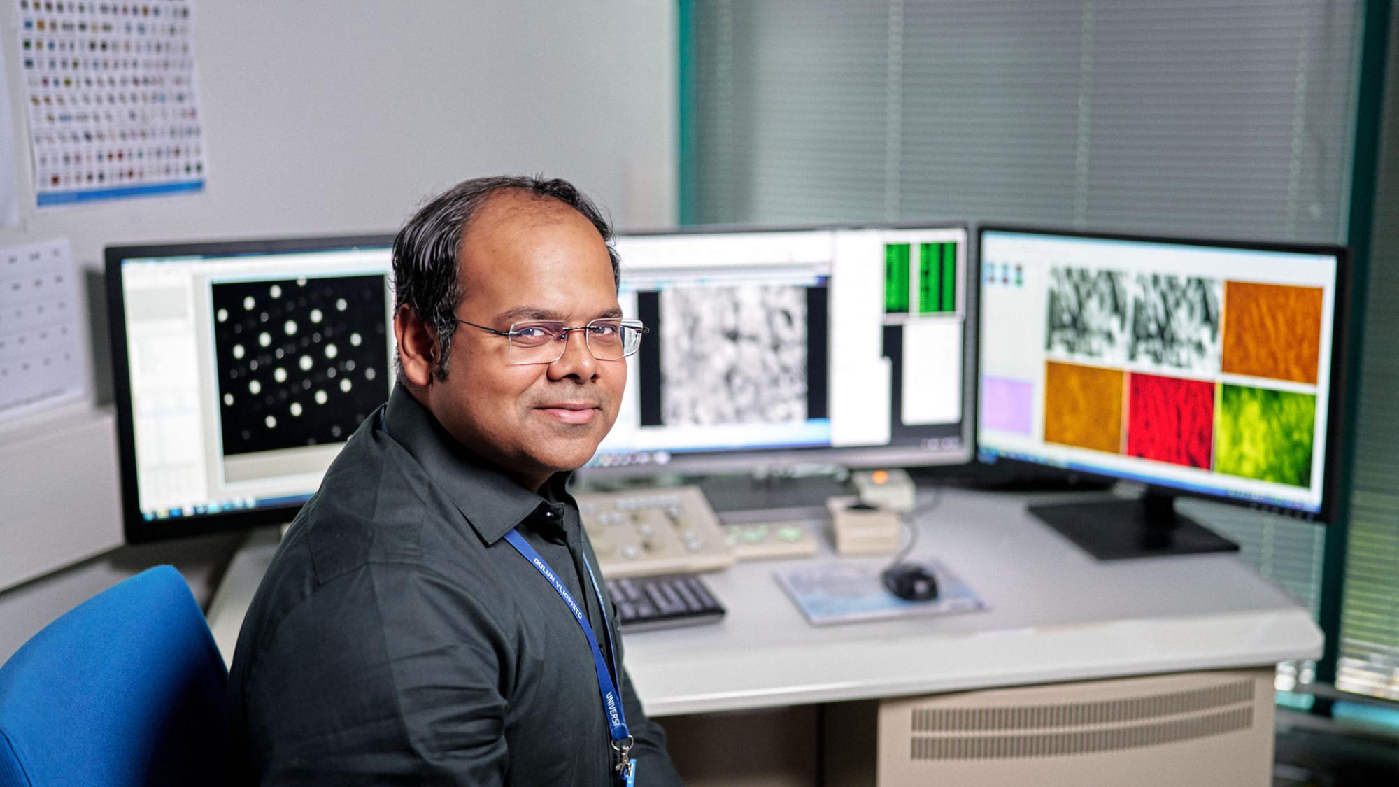 A researcherh is analysing data on computer screens