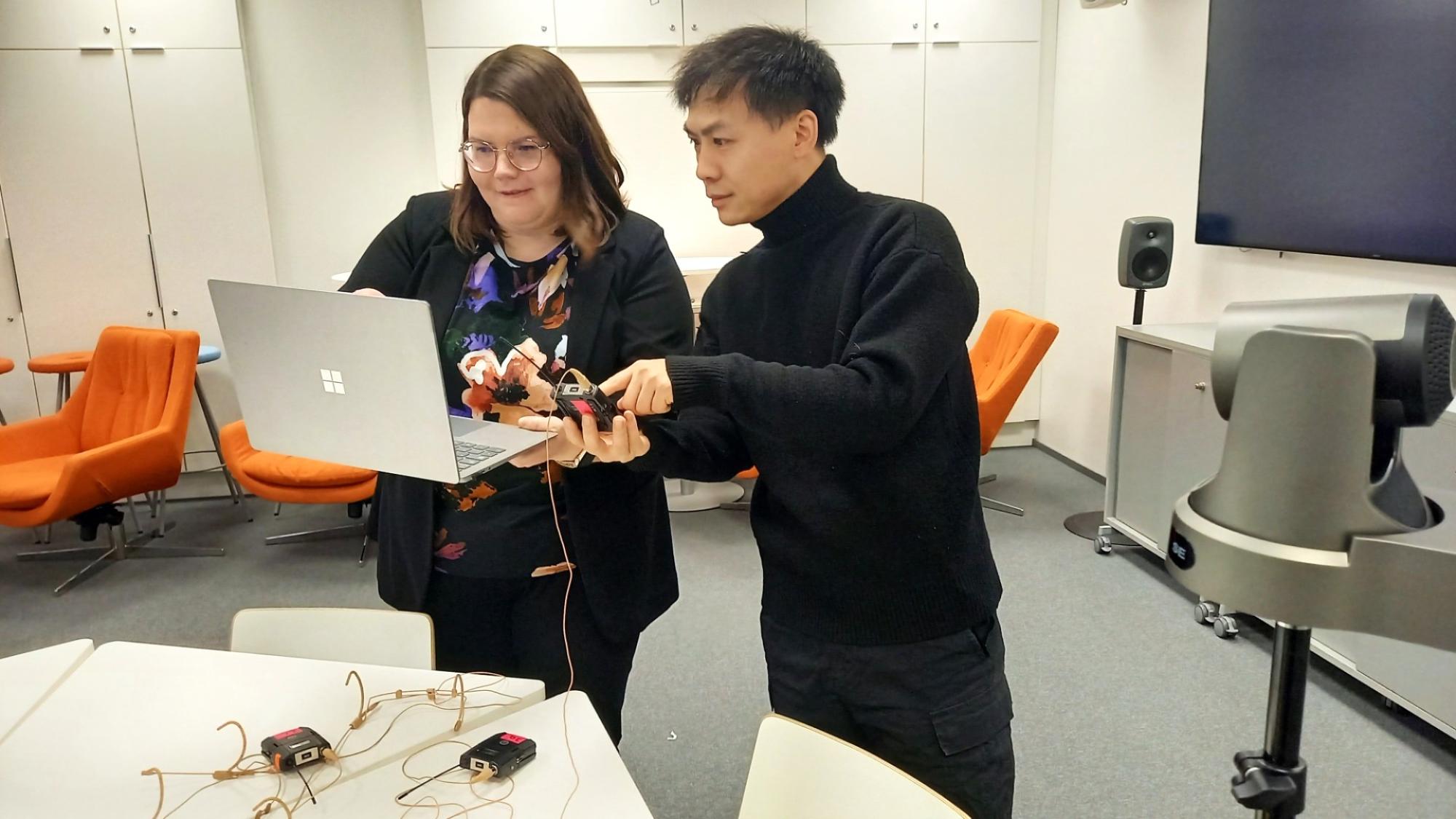 Researchers working together with labtops and microphones to set up a multimodal data collection