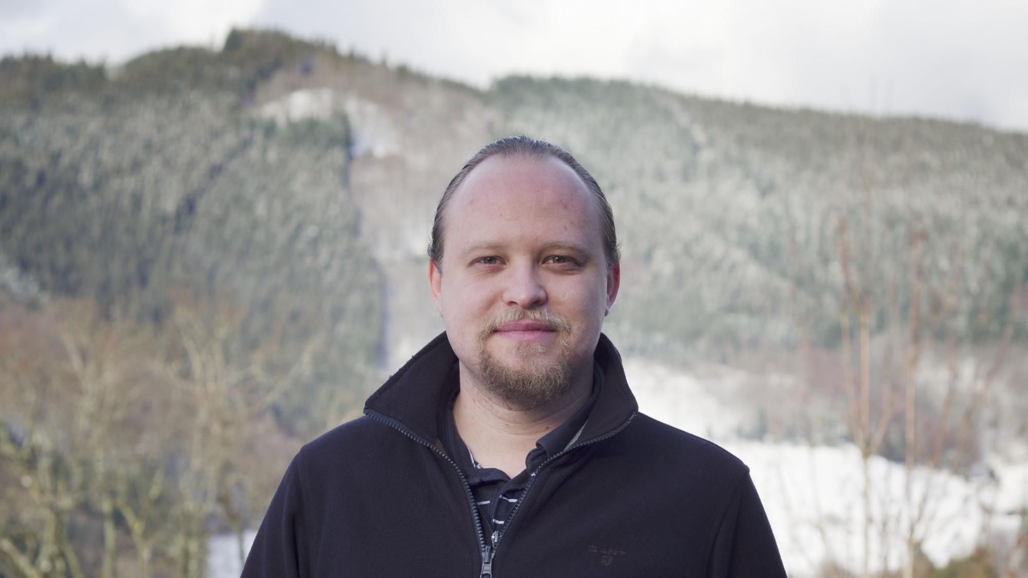 Andreas Hauptmann in front of mountain and forest