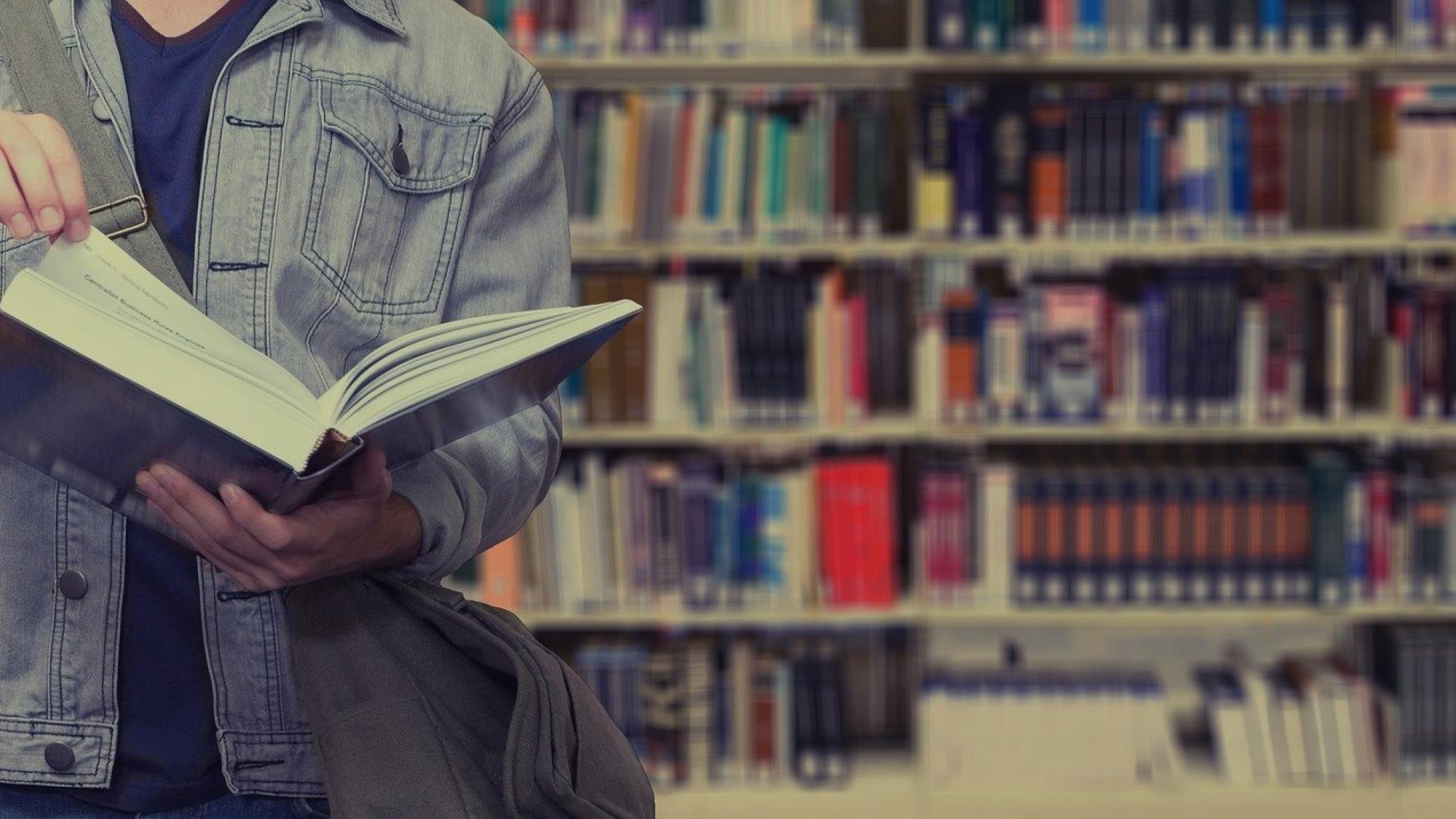 A person browsing a book in the library