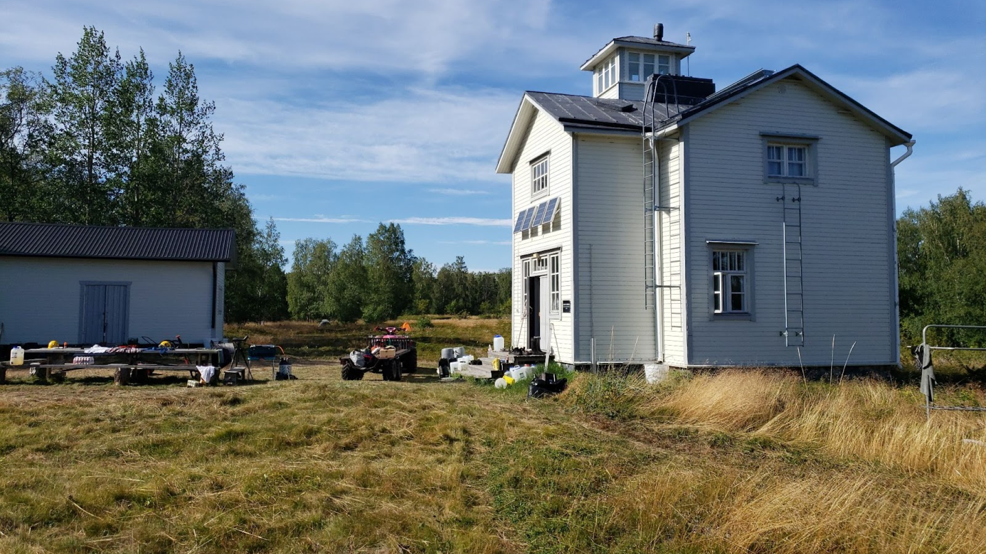 White wooden house in a meadow.