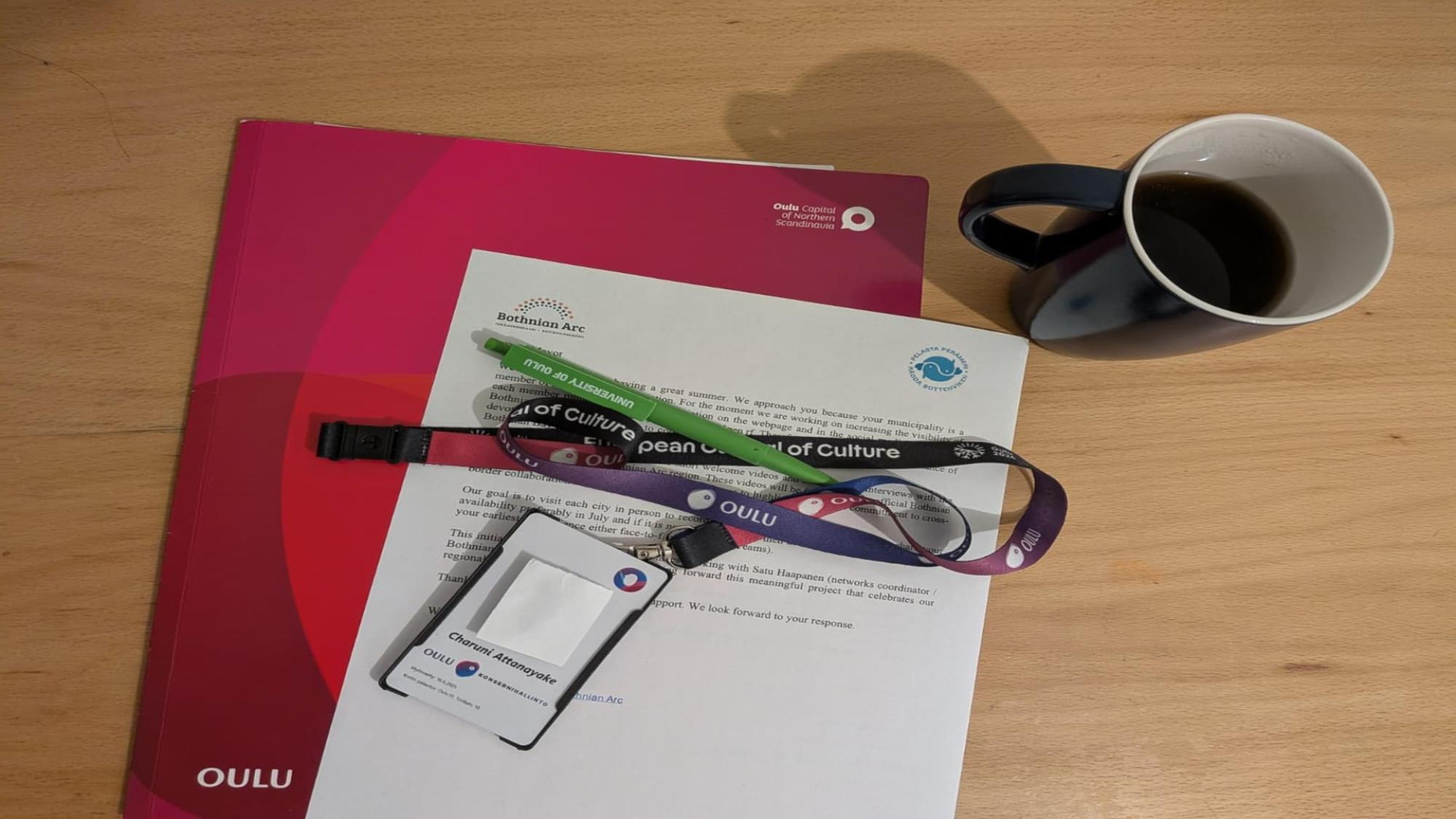 Coffee mug, papers and key card on a table