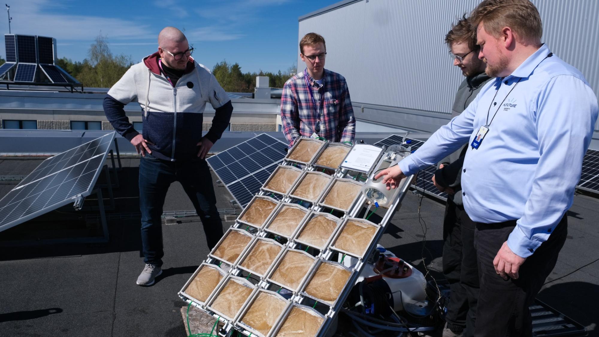 Tutkijoita katolla katsomassa aurinkovetypaneelia