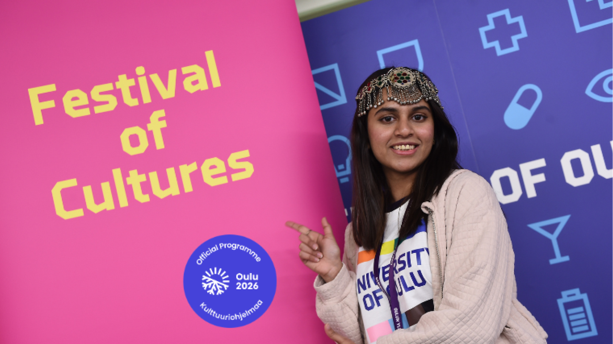 Student posing with pink and yellow Festival of Cultures roll up.