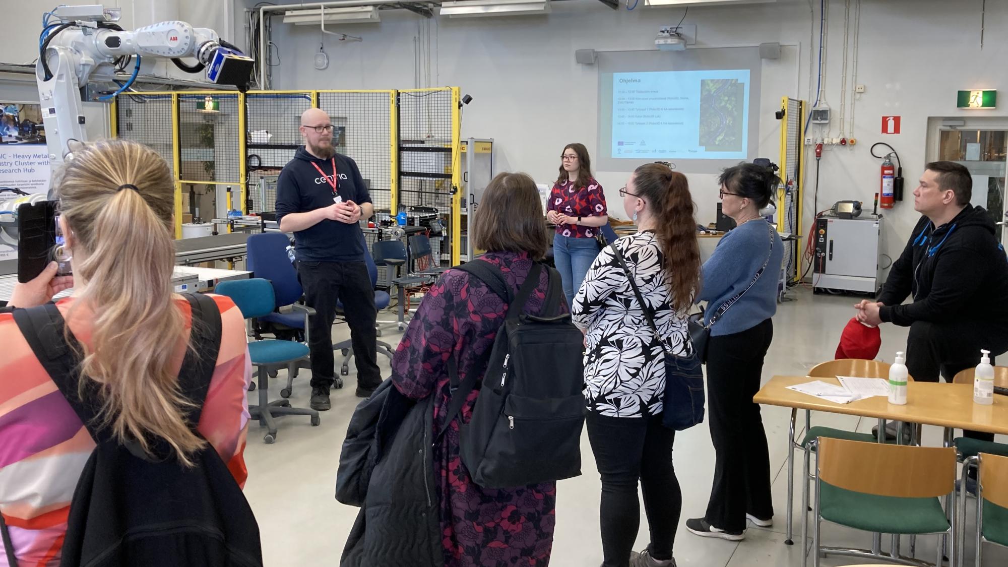 ryhmä ihmisiä kuuntelemassa esitystä laboratoriossa