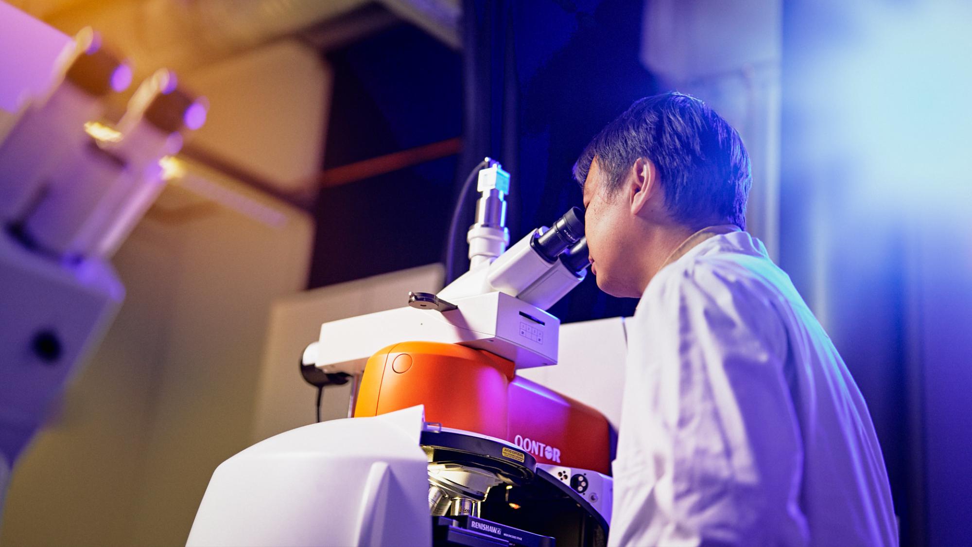 Akatemiatutkija Jianan Huang ja raman-mikroskooppi