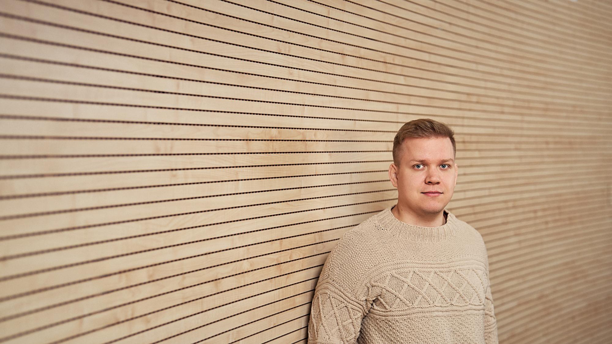Joona Lohtanderin tutkijaprofiilikuva. Rintakuva miehestä, jolla päällään villapaita. Taustalla vaalea puupaneeliseinä.