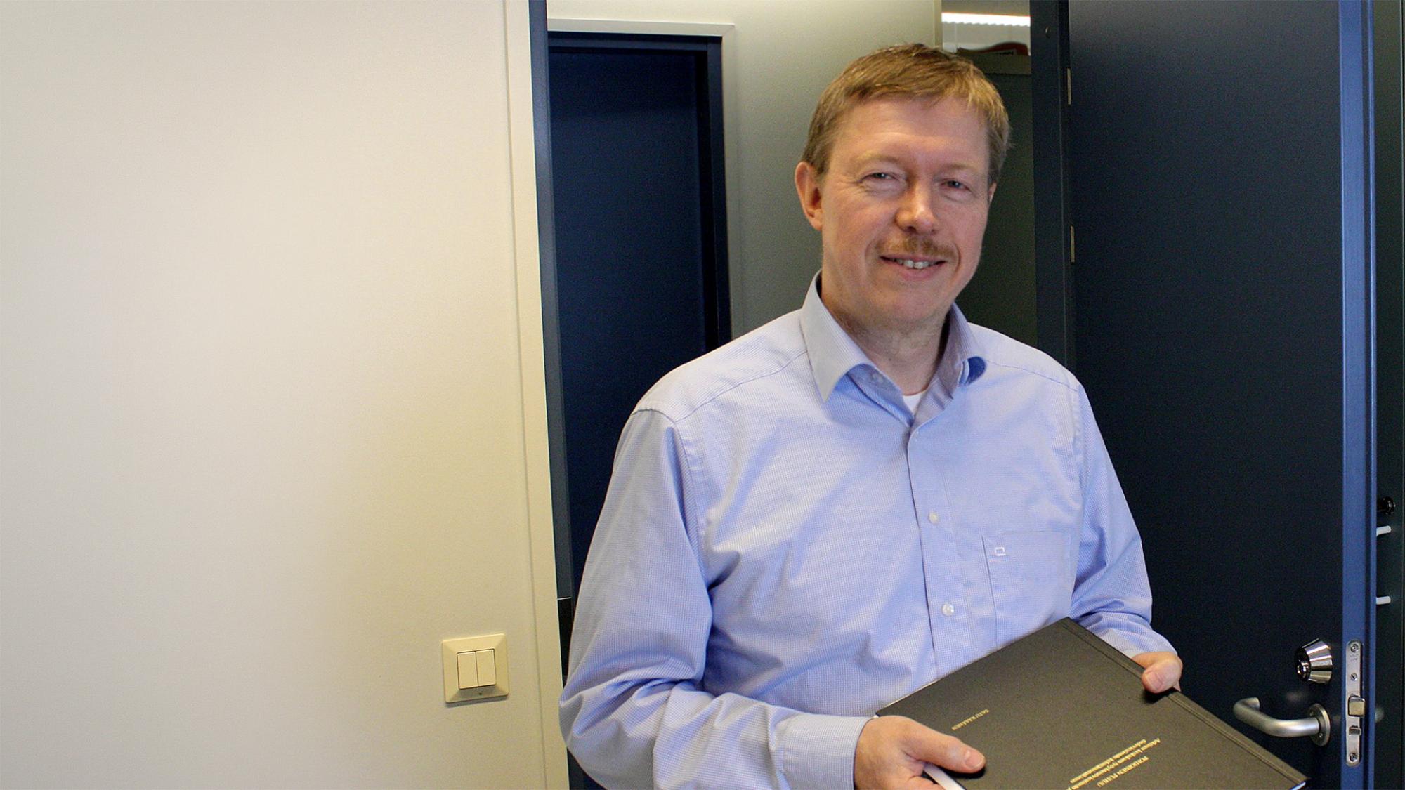 Professori Erkki Karvonen ja mustakantinen gradu.