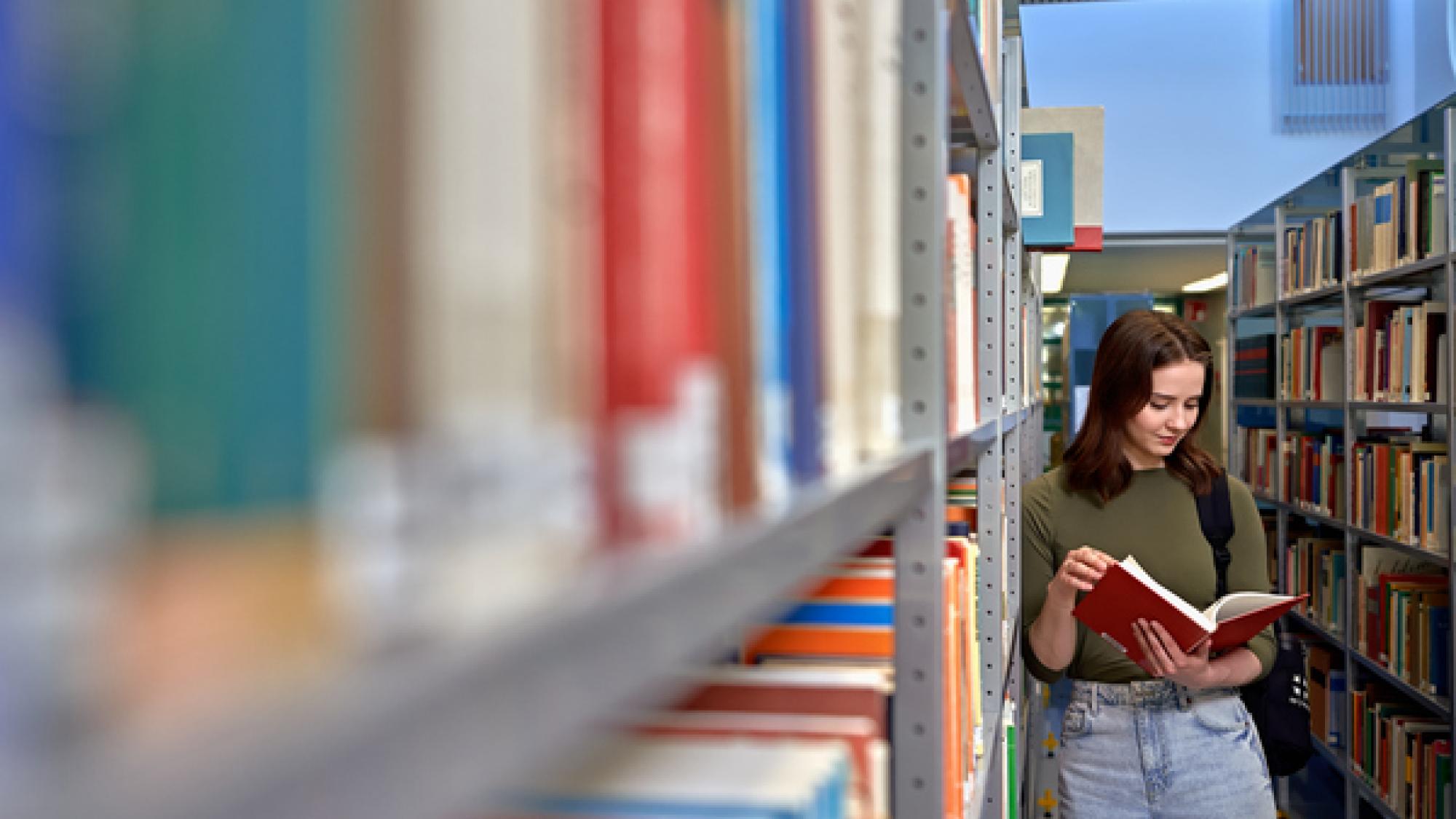 A person reading a book in a library