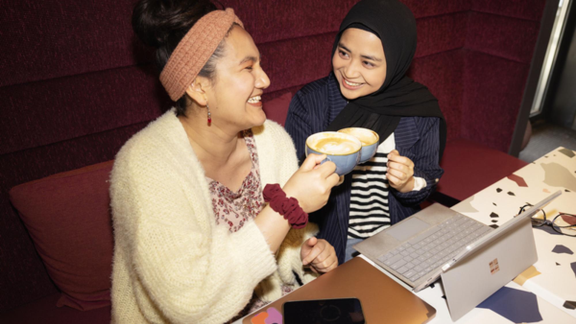 Kaksi opiskelijaa opiskelee yhdessä ja juo kahvia