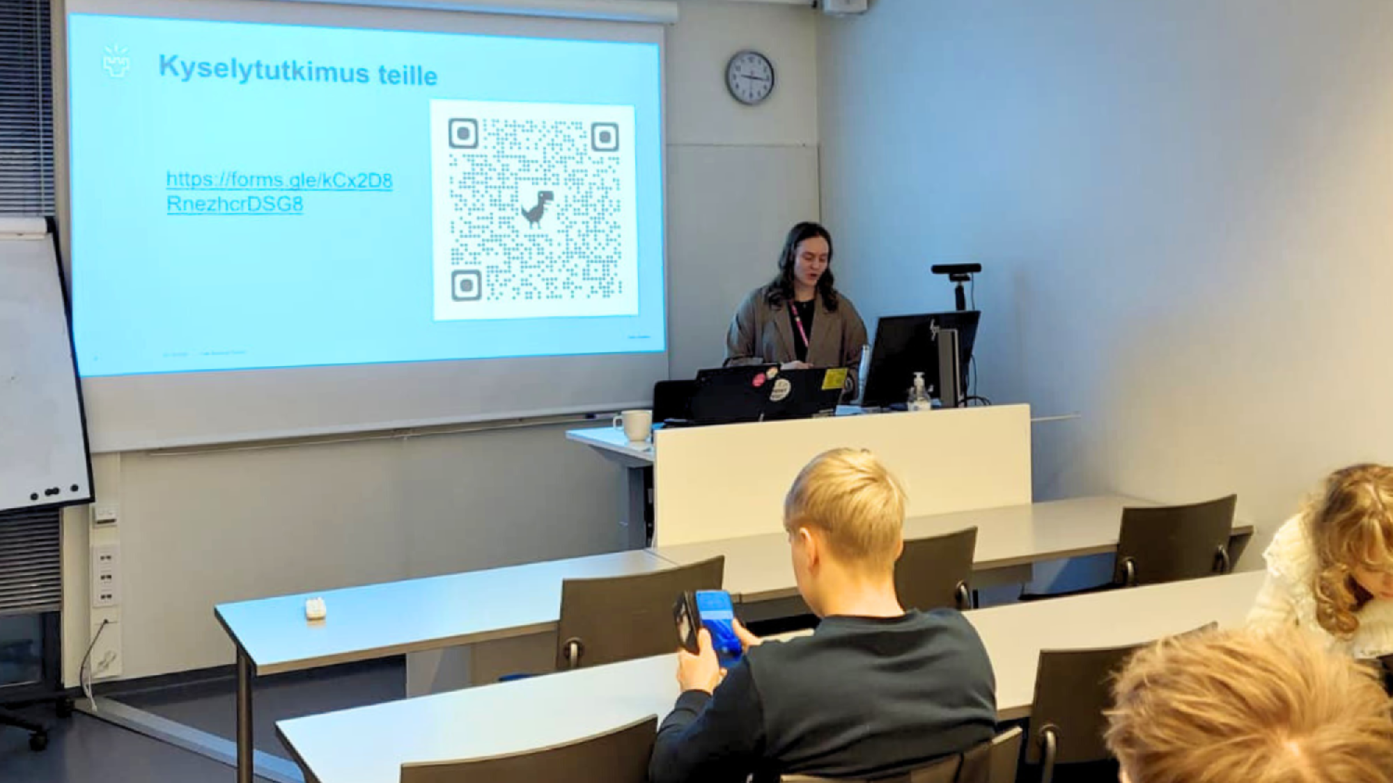 Väitöskirjatutkija Nea Kunnari pitämässä esitystä lukiolaisille.