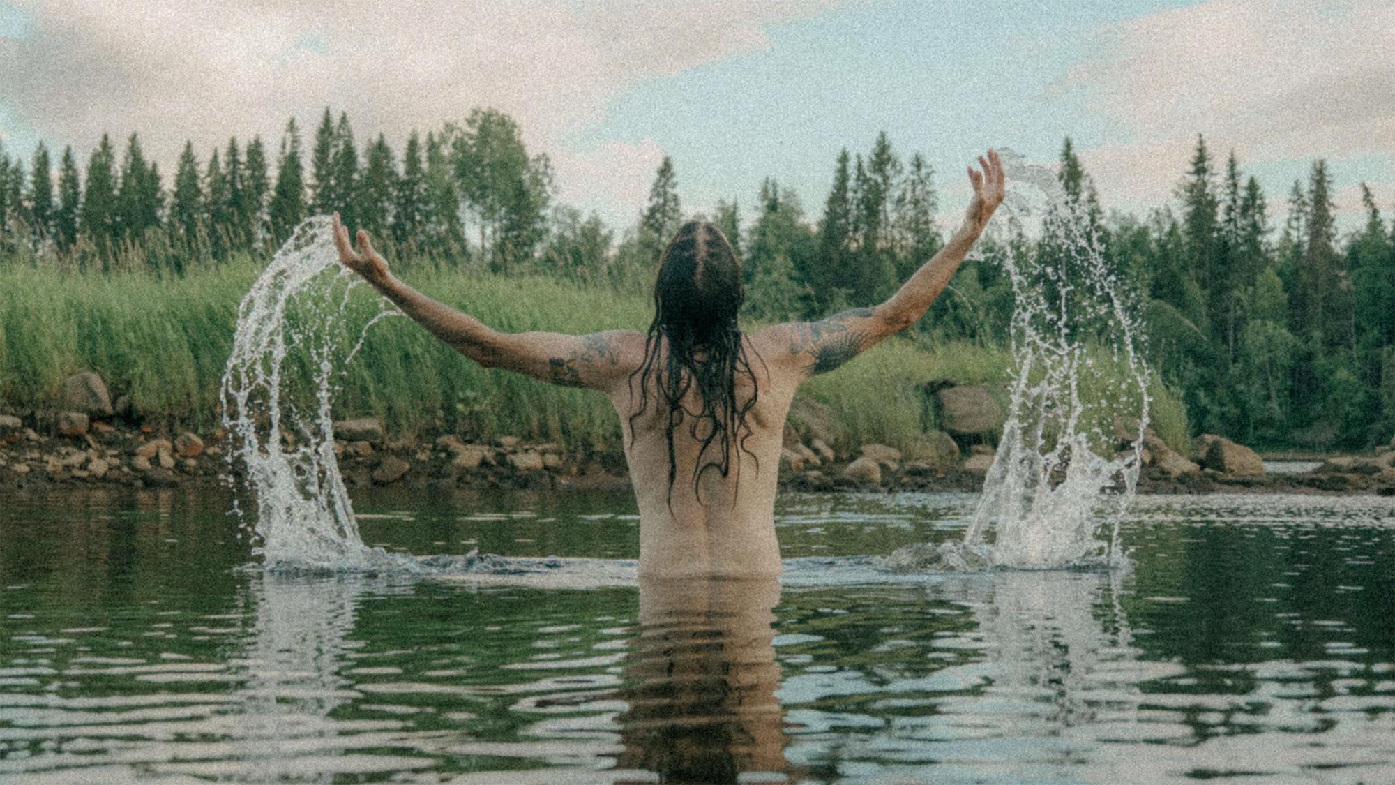 nainen pärskyttää vettä joessa