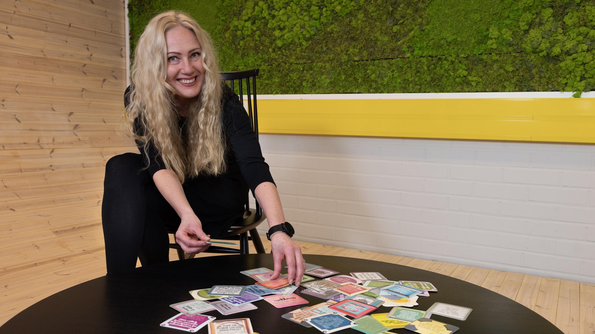 Päivi Lohikoski selailee pelikortteja