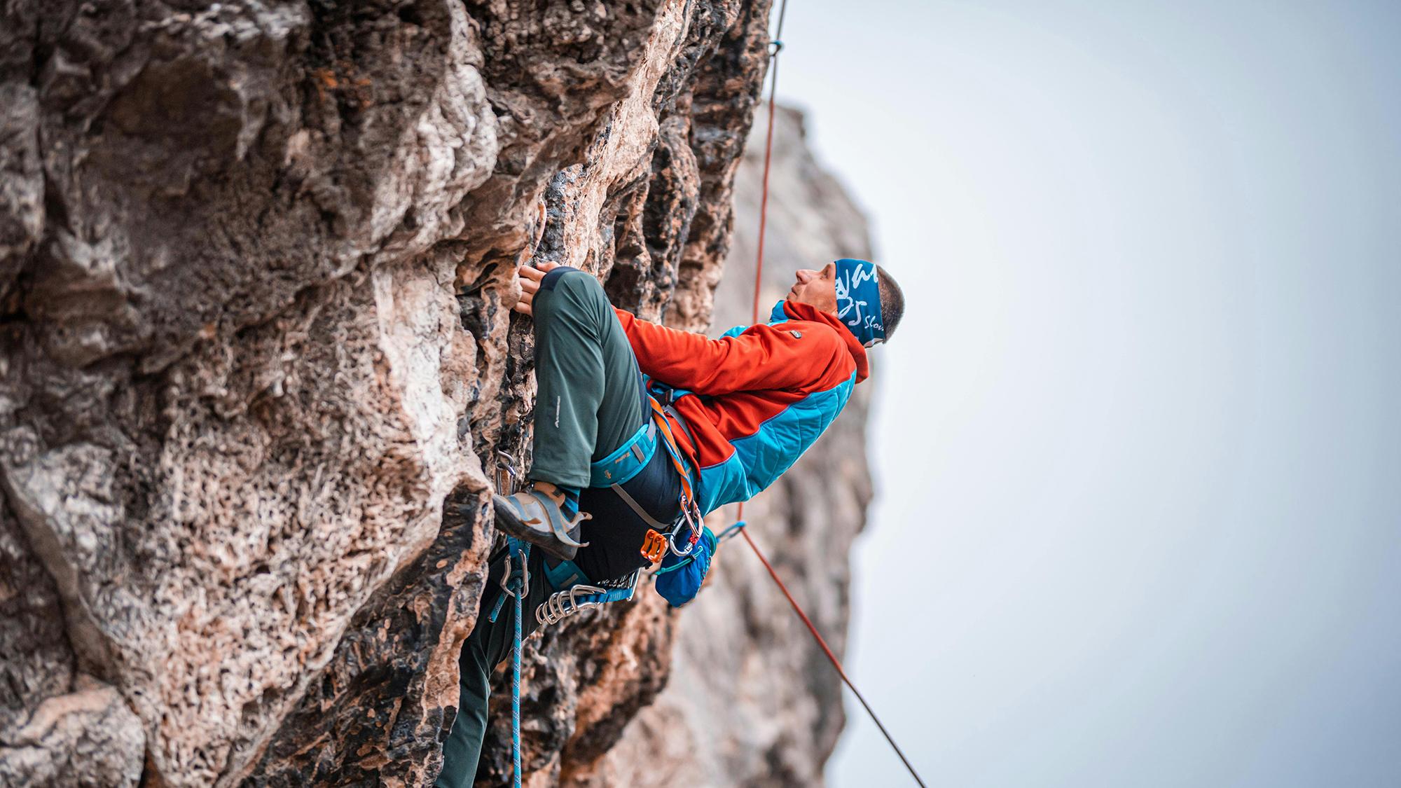 Mies kiipeää vuoren rinnettä