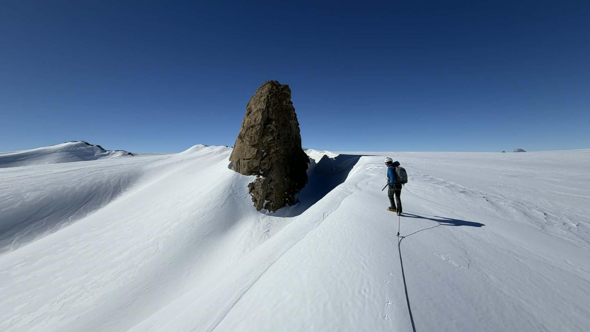Ice and snow on Antarctica and a person crossing the whiteness