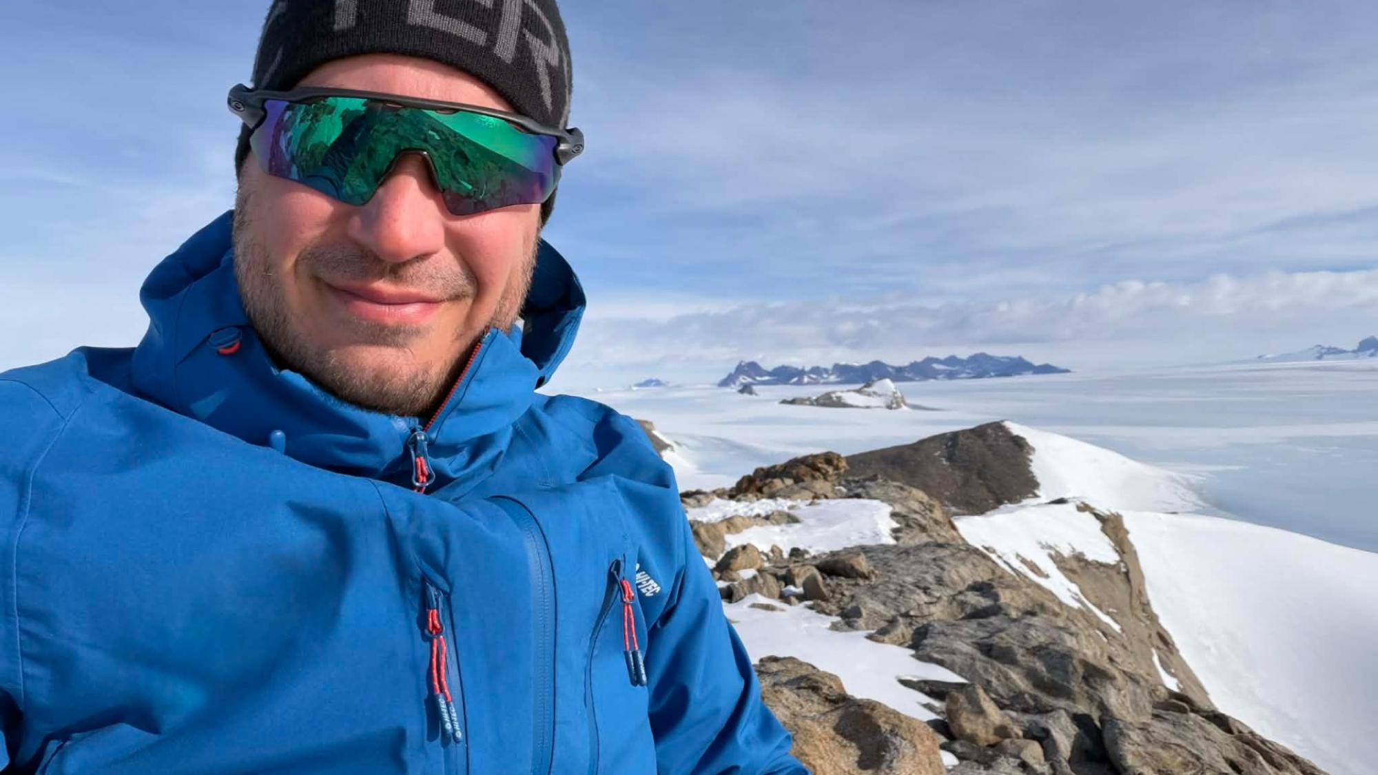 A man Standing atop a nunatak offers a stark perspective on Antarctica