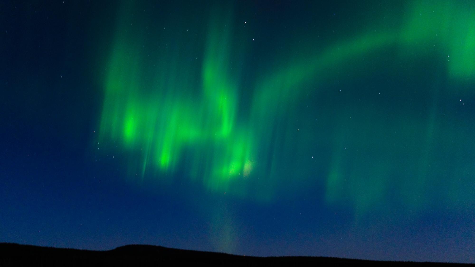 Northern Lights in green color on the sky in Rovaniemi rural area