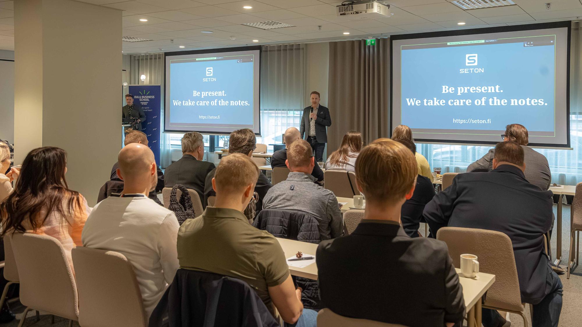 Saku Huttunen speaking in front of a crowd.