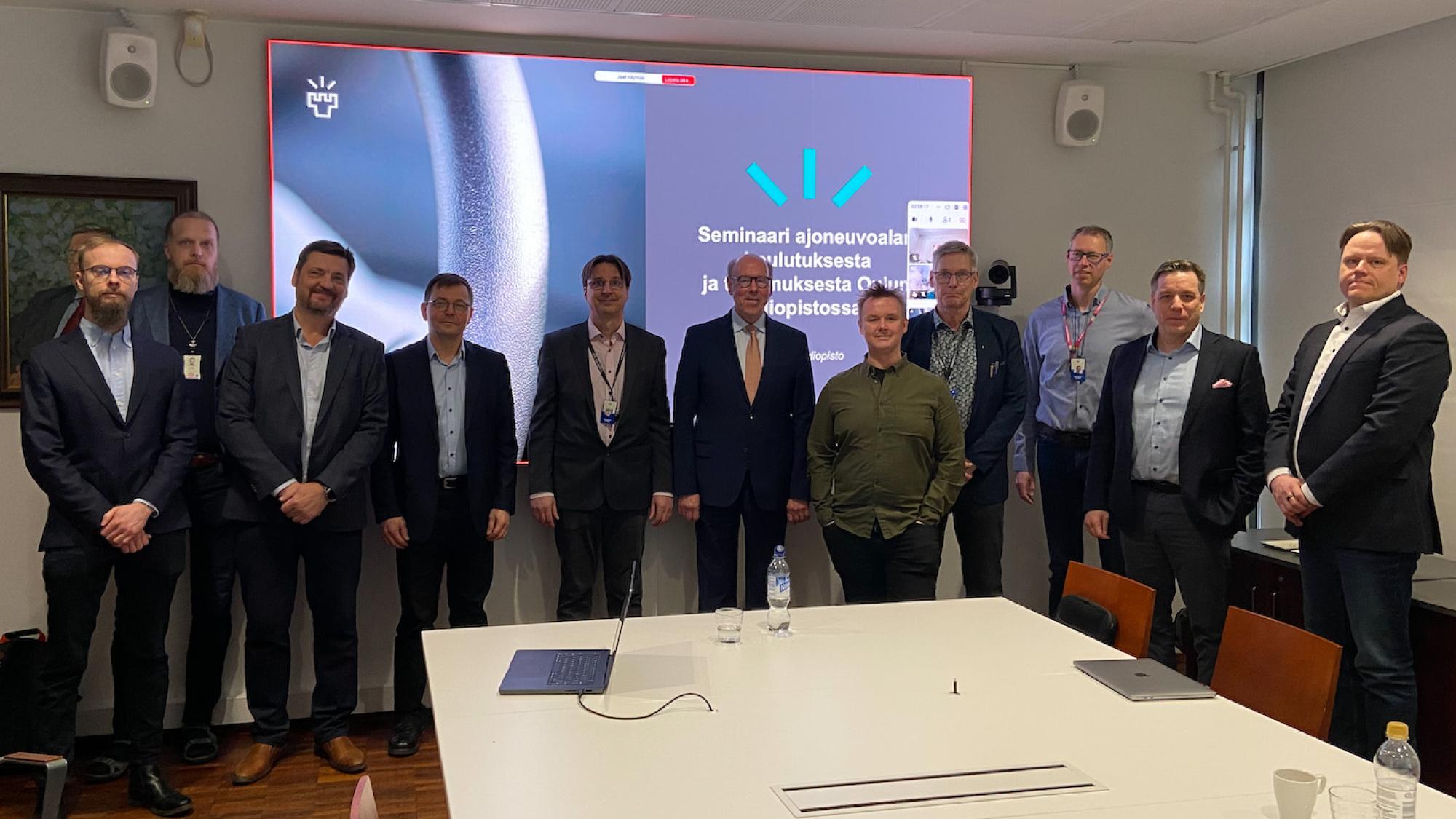 Group photo of eleven seminar participants gathered in front of a screen.