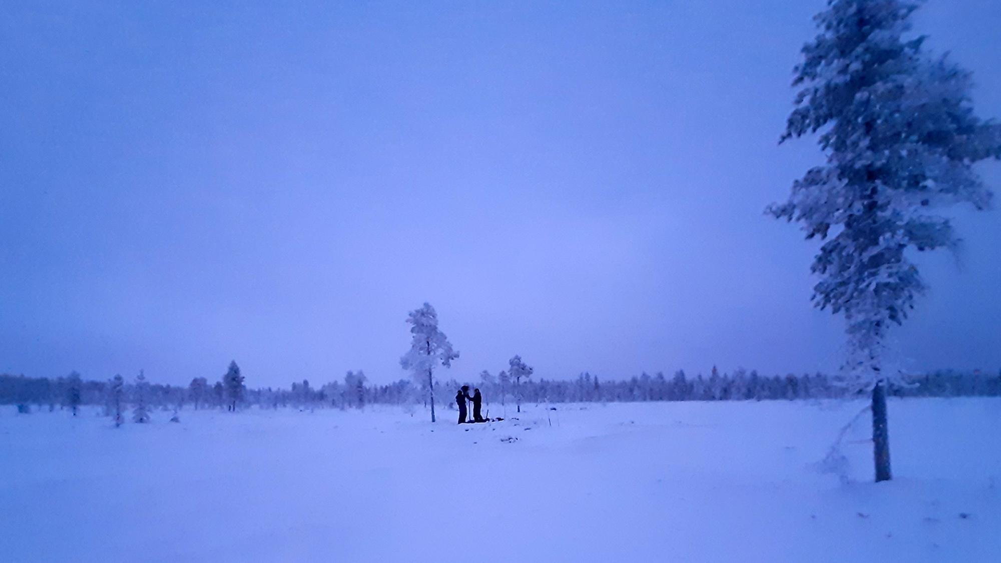 Kaksi henkilöä talvisessa suomaisemassa