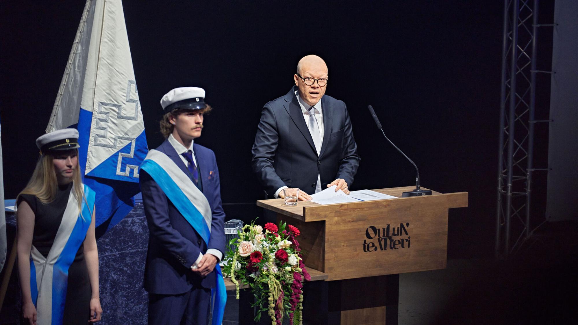 Petteri Alahuhta puhujanpöntössä ja airuet lippuvartiossa.