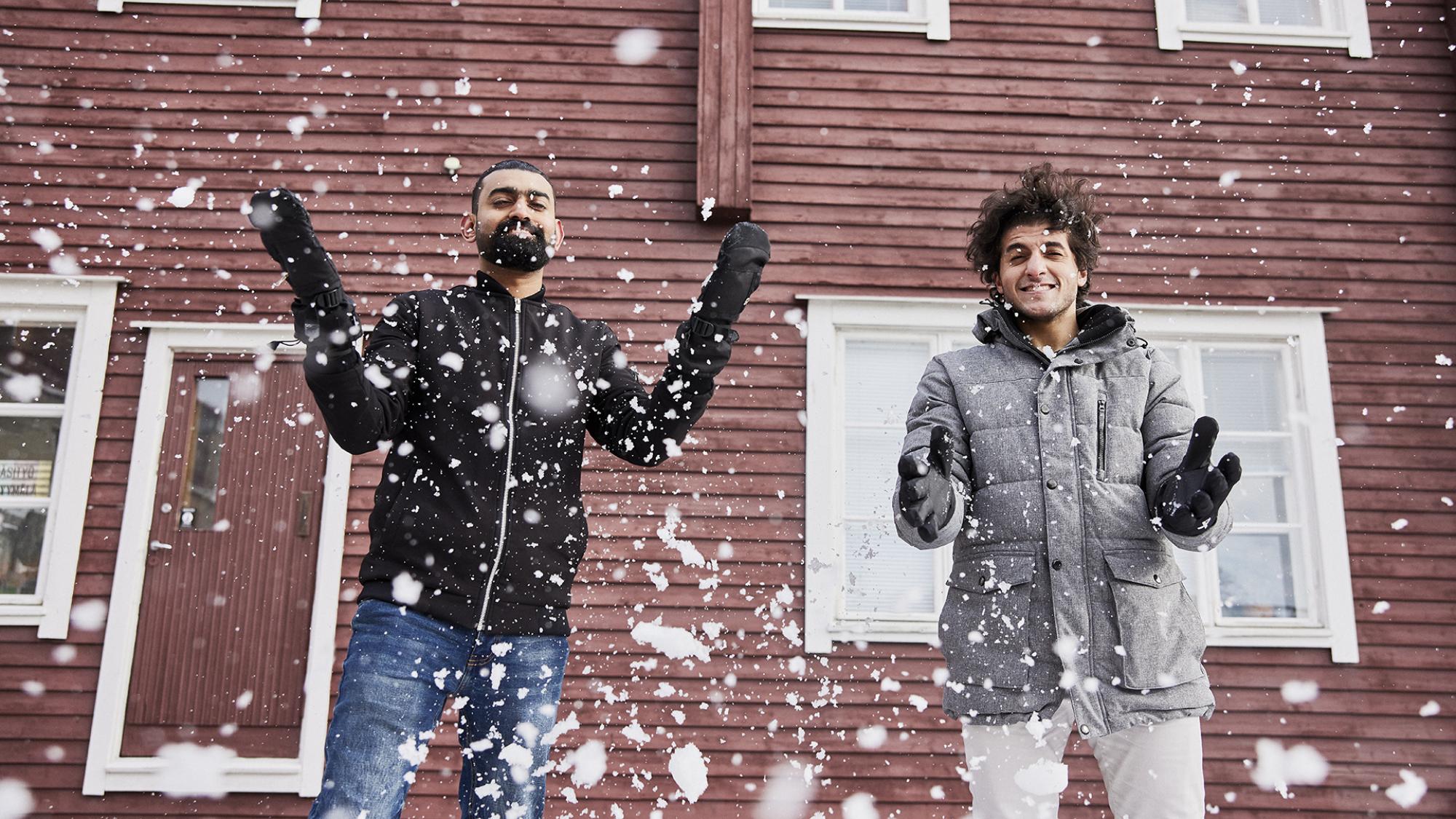 two men playing with snow