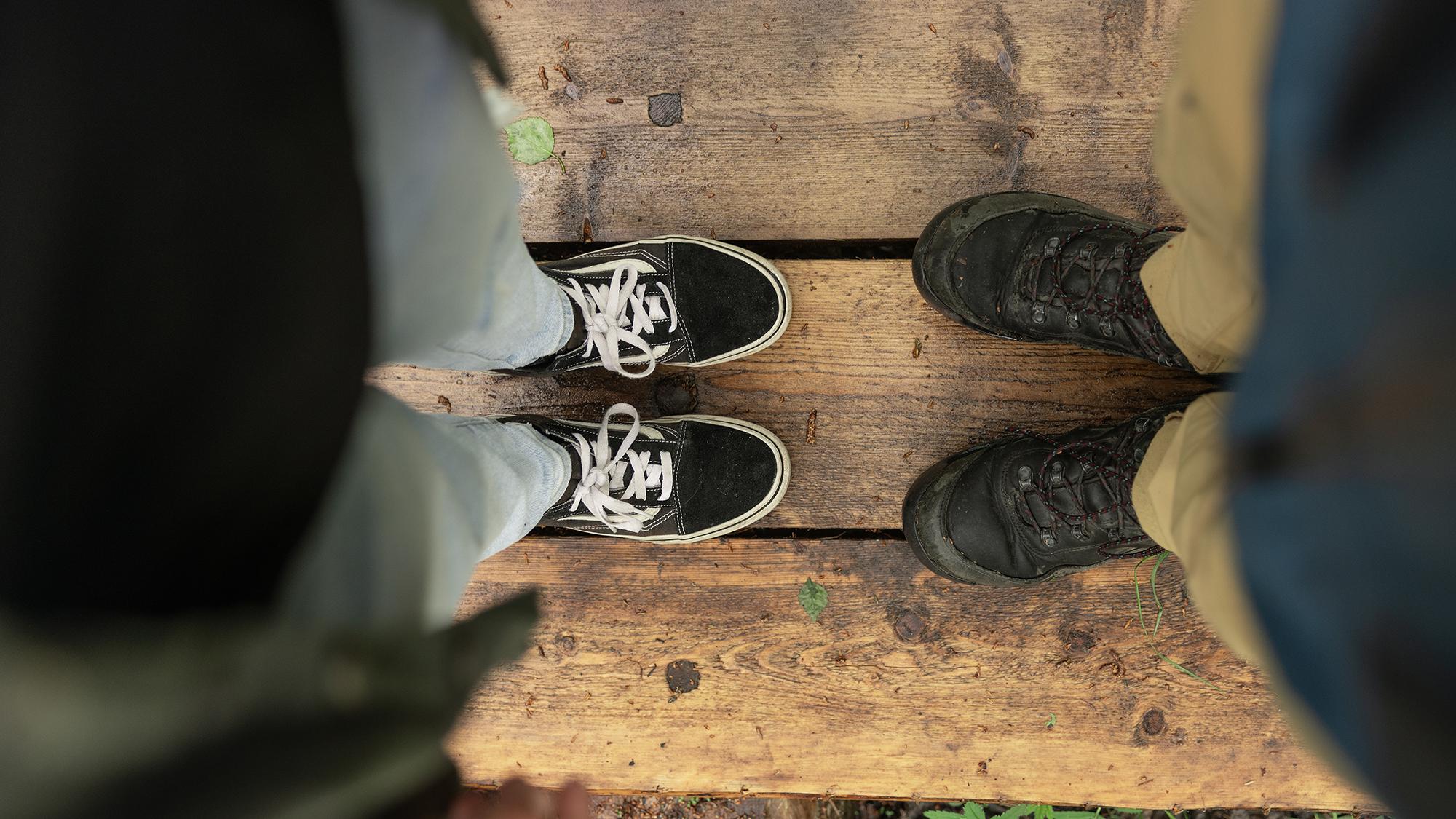 ylhäältä kuvattuna kahden ihmisen jalat vastakkain